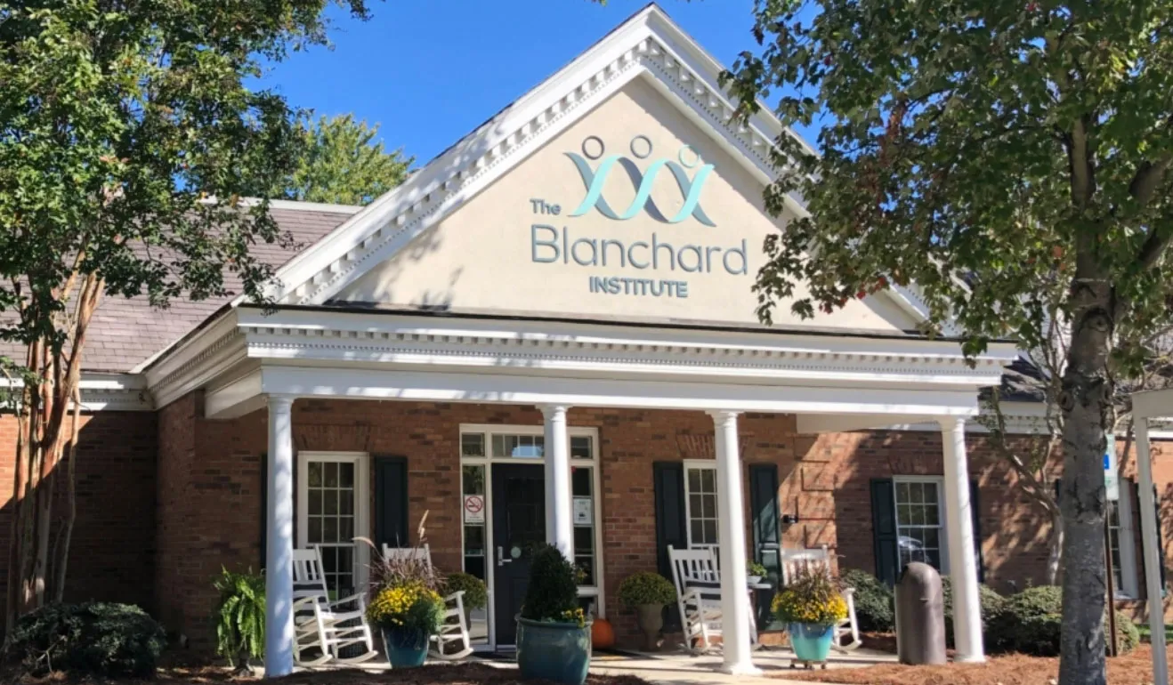 The Blanchard Institute outpatient treatment facility in Charlotte with white columns, brick exterior, and welcoming front porch with rocking chairs